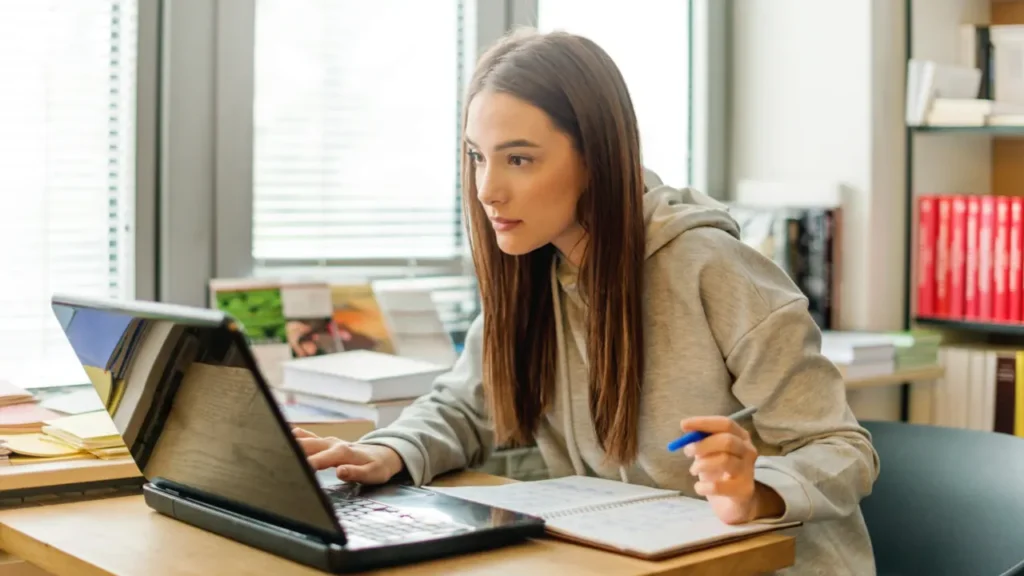 Young girl is working on laptop. 