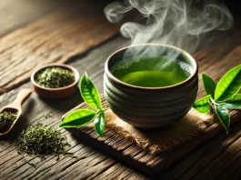 A steaming cup of green tea in a rustic ceramic mug on a wooden table, accompanied by fresh green tea leaves, with soft natural lighting enhancing its vibrant green color.